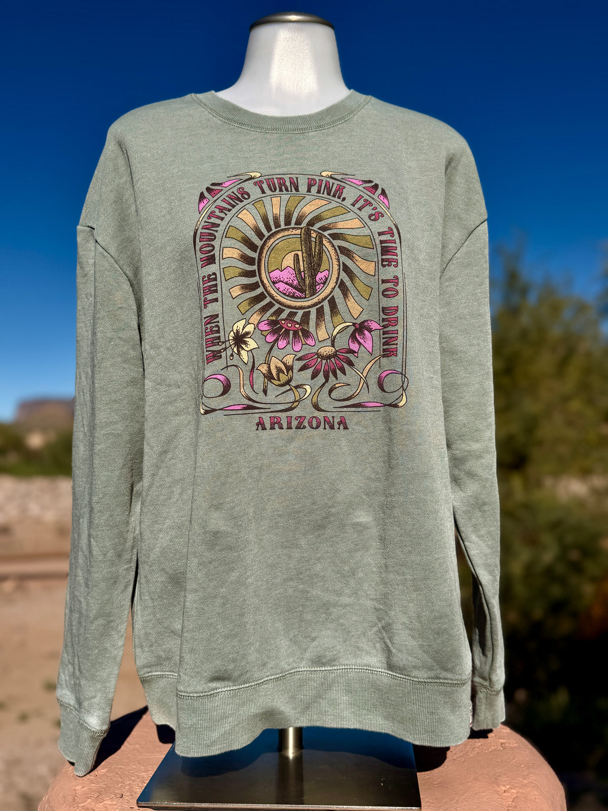 Vintage wash sweatshirt featuring an Arizona desert graphic with a Saguaro cactus, wildflowers, and a sunset sunburst design.